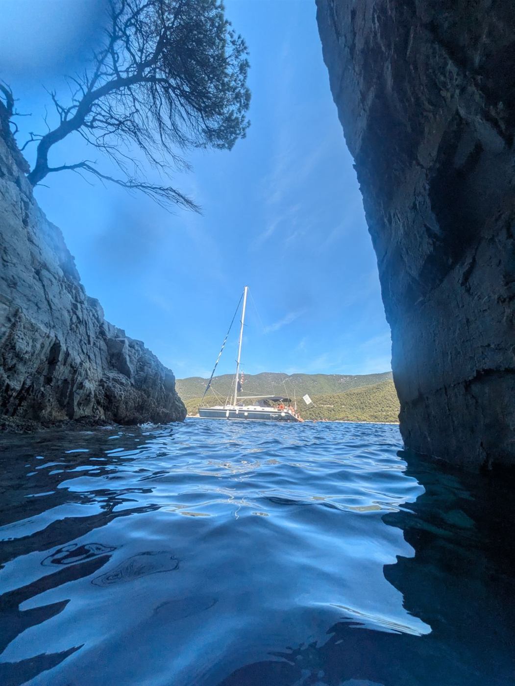 A sailboat resting deep inside a blue cove