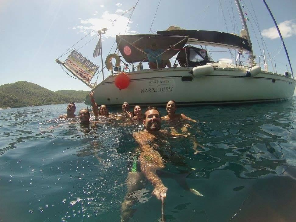 A happy group swimming behind the anchored yacht