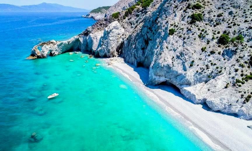 Aerial view of a white-pebble beach and turquoise lagoon