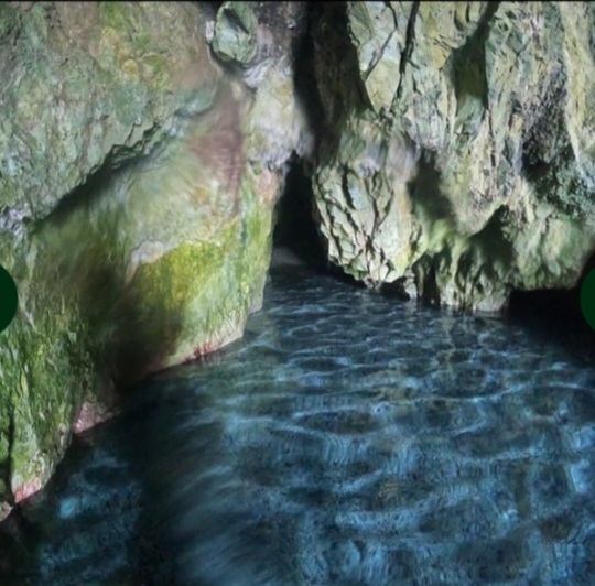 Inside the sea cave, light dancing on the water